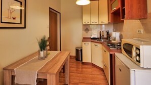 Una cucina compatta con mobili in legno, un tavolo da pranzo con una panca e un lampadario.