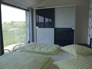 Ein Zimmer mit einem Bett, einem Fenster und einem Kleiderschrank.