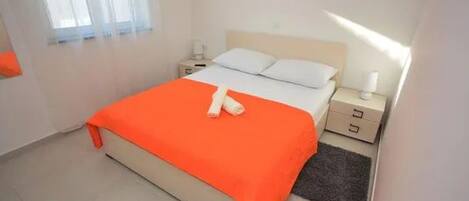 Ein Hotelzimmer mit einem Bett, einem Nachttisch, einer Lampe und einem gerahmten Bild an der Wand.