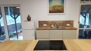 Una cocina con encimera de madera, estufa integrada y un lavamanos.