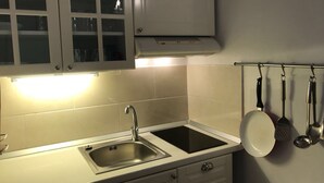 A kitchen with a double sink, cabinets, and a range hood. - Ferienwohnung by Interhome (Orebić)