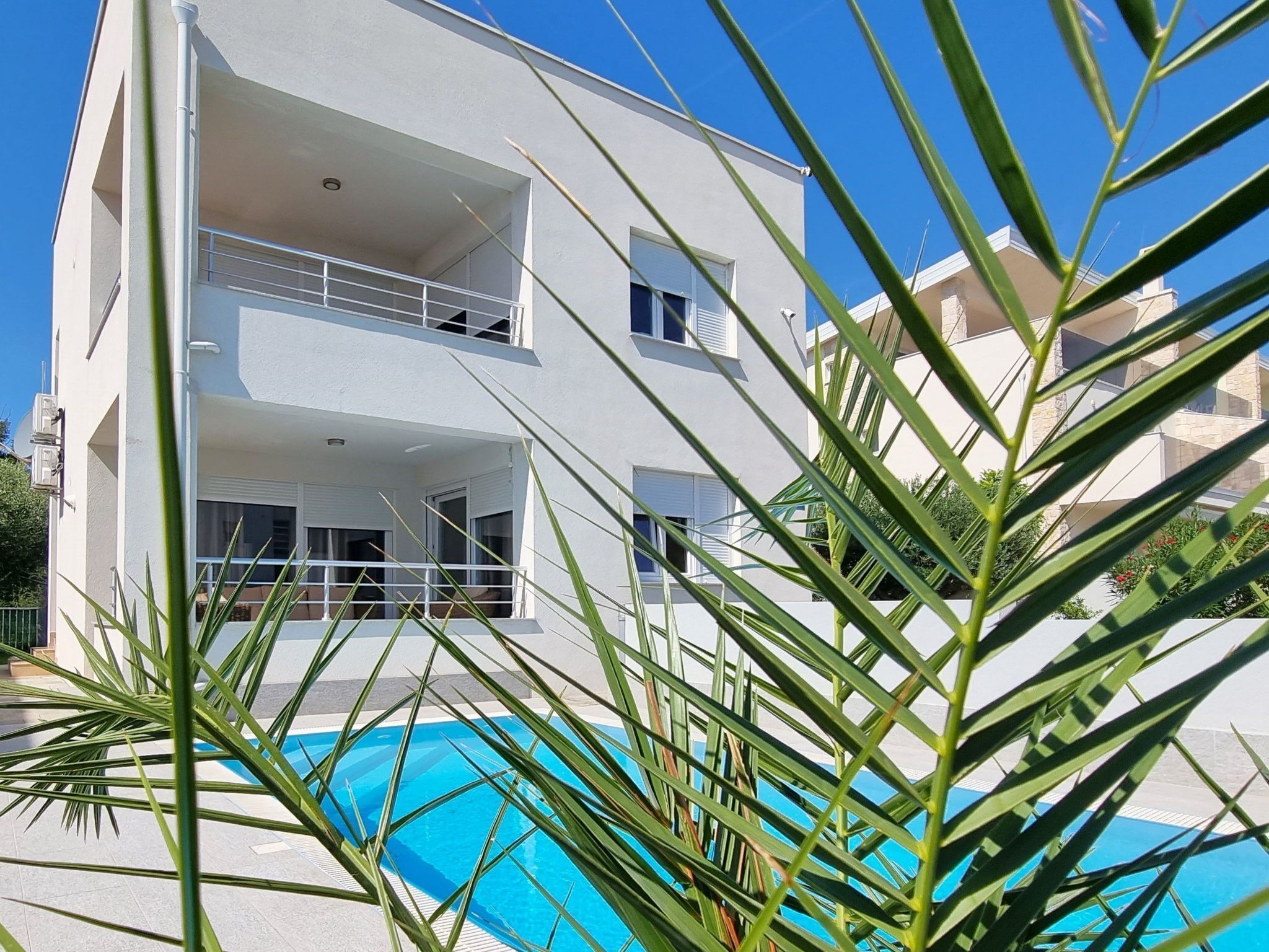 A multi-story building with a swimming pool in the foreground.