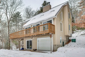 A two-story house with a wooden deck and a garage. - Snowmobile Trails & Ice Fishing in Wakefield (Sanbornville)