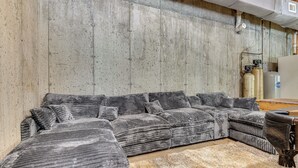 A sectional sofa with multiple cushions, a wooden floor, and a rug. - Waterfront Wakefield Retreat w/ Floating Dock (Sanbornville)