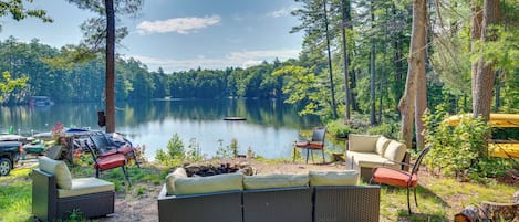 A lakeside outdoor seating area with wicker furniture and a view of the lake.