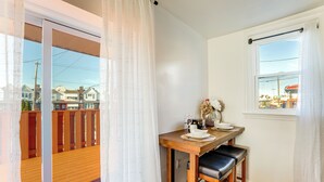 Ein Essbereich mit Holztisch, zwei Stühlen und einem Fenster mit Blick auf Häuser.