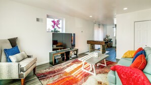 Ein modernes Wohnzimmer mit einer Couch, einem Couchtisch und einem Fernseher.