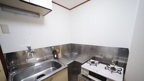 A compact kitchen with a stainless steel sink, a gas stove, and beige cabinetry. - Tokyo Quiet Residential Studio FMC Asagaya | 3min To Station, Direct Shinjuku (Asagayaminami, Suginami)