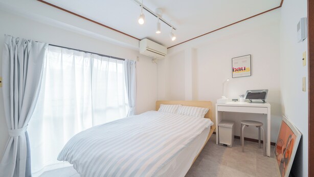 A bedroom with a bed, a desk, and an air conditioning unit. - Tokyo Quiet Residential Studio FMC Asagaya | 3min To Station, Direct Shinjuku (Asagayaminami, Suginami)
