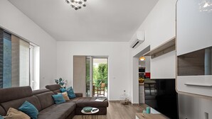 Un salon moderne avec un canapé d’angle, un téléviseur à écran plat et une table basse en bois.