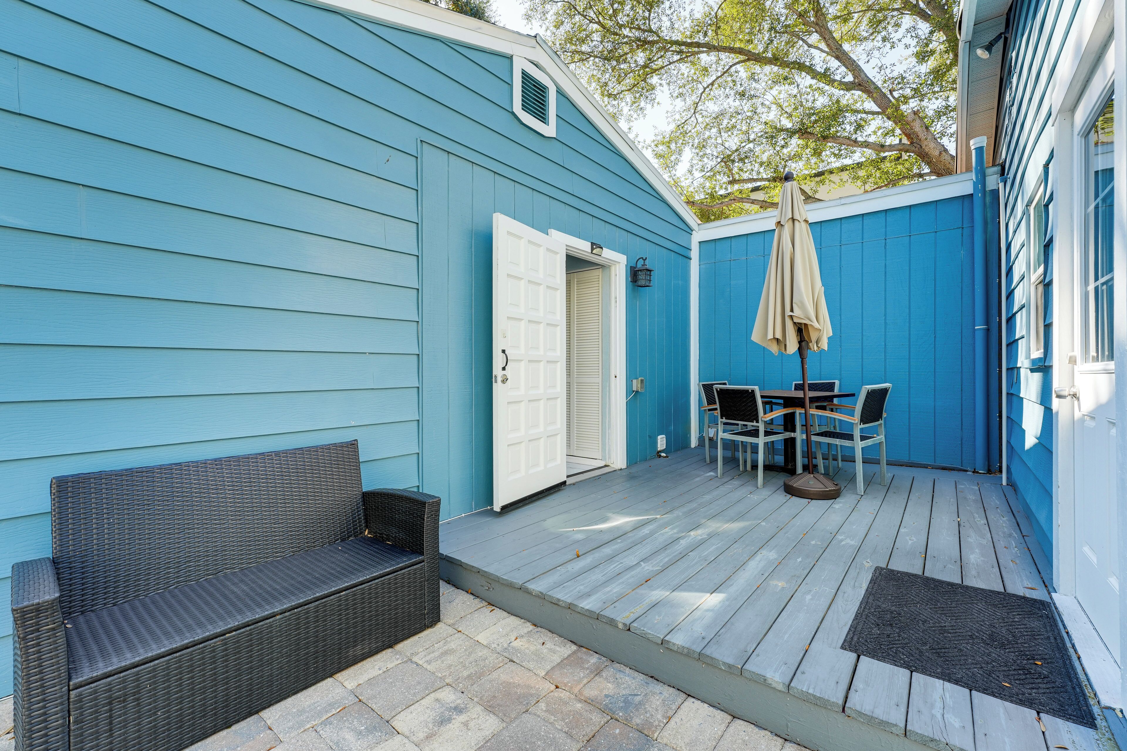 Ein blaues Haus mit einer Veranda, einem Tisch mit Stühlen und einer Bank.