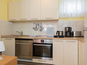 Eine moderne Küche mit Edelstahlgeräten, darunter ein Geschirrspüler, ein Backofen und eine Kaffeemaschine.