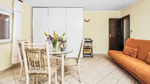 A dining area with a glass table, chairs, a vase of flowers, and a baby stroller. - Panoramare by Interhome (Plomin)