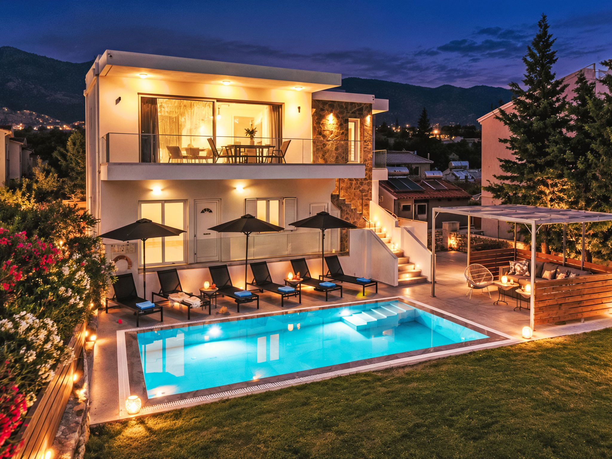 Ein modernes Haus mit zwei Etagen, einem Schwimmbad, Außenbereich-Sitzgelegenheiten und Bergblick.