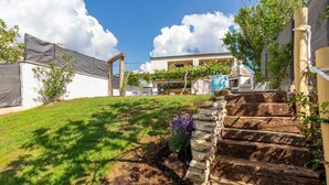 Ein Wohnhaus mit einer Steintreppe, einem Rasen und blauem Himmel.