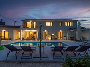 A two-story house with a swimming pool, outdoor seating, and a stone facade. - Designer Villa Simone - Modern und Heritage Style by Interhome (Jakovici)