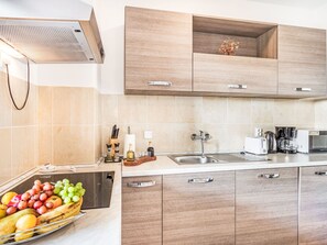 A modern kitchen with wooden cabinets, a stainless steel sink, and a built-in oven. - Wohnung "Wohnung Sterna mit Pool" by Interhome (Svetvinčenat)