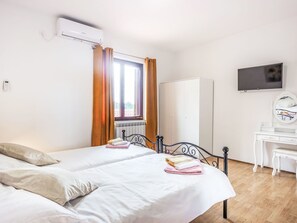 Une chambre d’hôtel équipée d’un lit, d’un bureau, d’une armoire et d’un téléviseur.