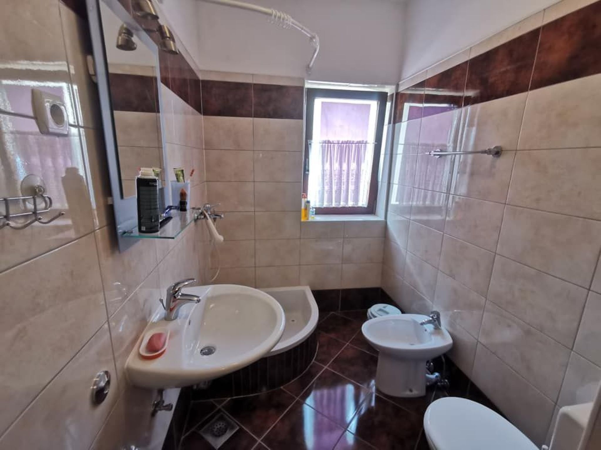 Een kleine badkamer met een wastafel, toilet en bidet.