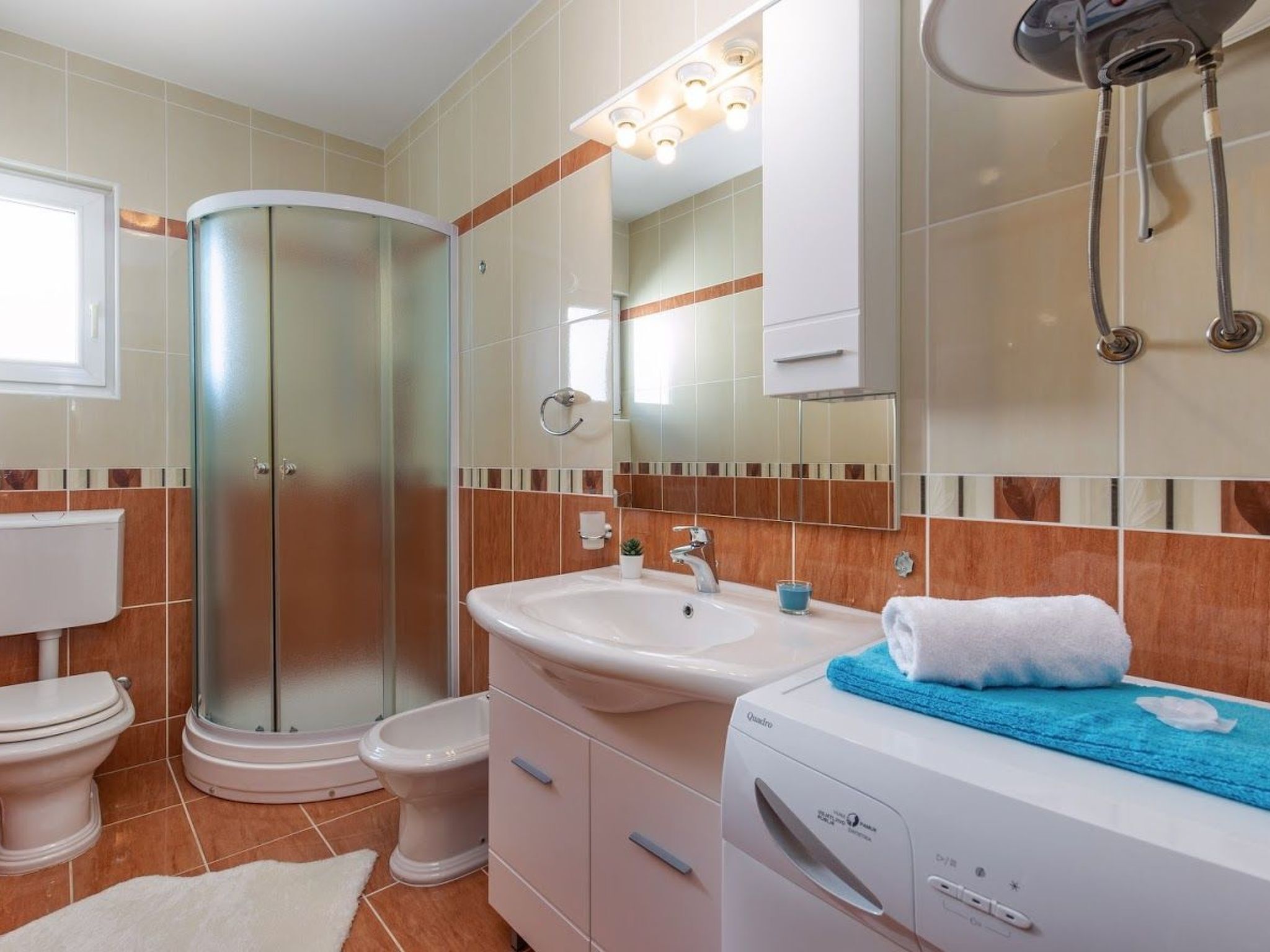 Un bagno con doccia, toilette, lavandino e specchio.