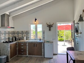 Ett modernt kök med en inbyggd diskmaskin, träskåp, en gasspis och ett fönster med utsikt över grönområden.