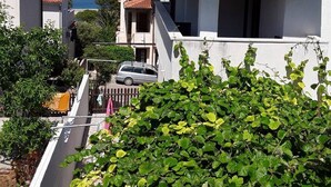 A coastal residential area with white buildings, red-tiled roofs, and a view of the sea. - Studioapartment Meri 4 by Interhome (Losinj / Mali Losinj)