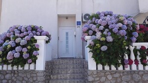 A building with a stone staircase leading to a white door marked with the number 24. - Studioapartment Meri 4 by Interhome (Losinj / Mali Losinj)