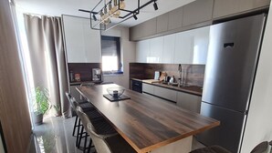 Eine moderne Küche mit einer Holzinsel, Edelstahlgeräten und Barhocker.