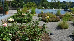 A garden with a fountain, potted plants, and a gazebo. - Sunnebad Sternenberg by Interhome (Sternenberg)