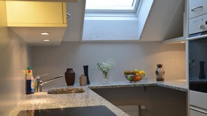 A modern kitchen with granite countertops, a built-in oven, and a skylight above the sink. - Sunnebad Sternenberg by Interhome (Sternenberg)