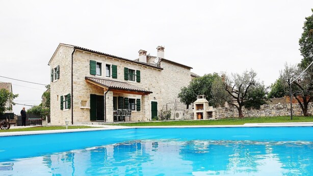 Un edificio de piedra con una piscina delantera.