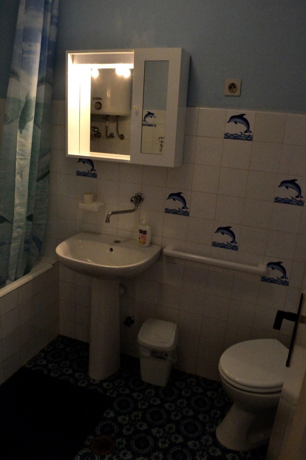 Une salle de bain avec un lavabo, des toilettes et un miroir au-dessus du lavabo.