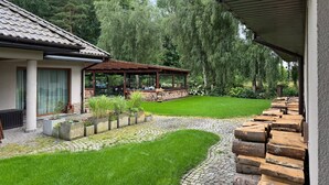 Een huis met een overdekte patio, een pad van stenen en een verzorgd gazon.