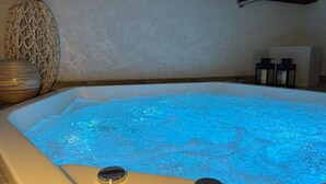 Een hottub met een houten plafond en een structuurwand.
