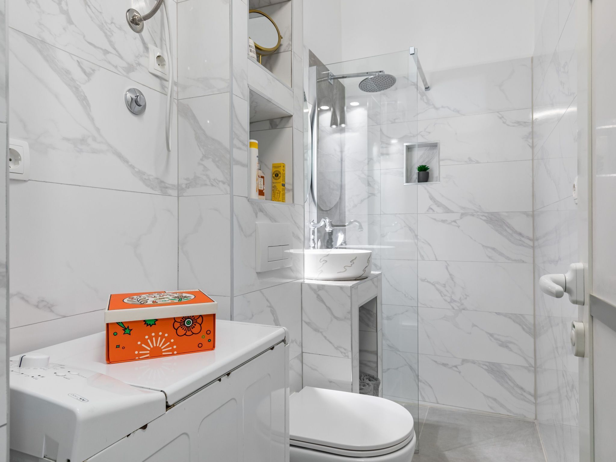A modern bathroom with a toilet, sink, and shower.