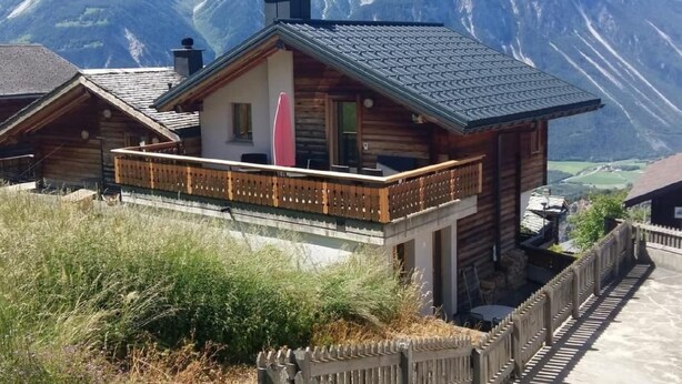 A wooden chalet with a balcony, set against a mountainous backdrop. - Chalet Angelika by Interhome (Albinen)