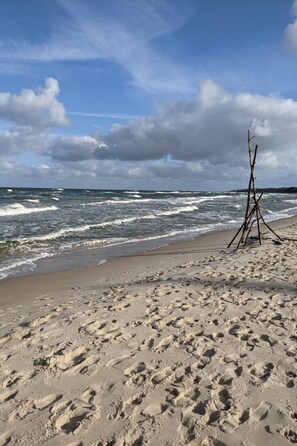 A sandy beach with footprints and a wooden structure. - Sunset Resort, Wohnung in Grzybów by Interhome (Grzybowo)