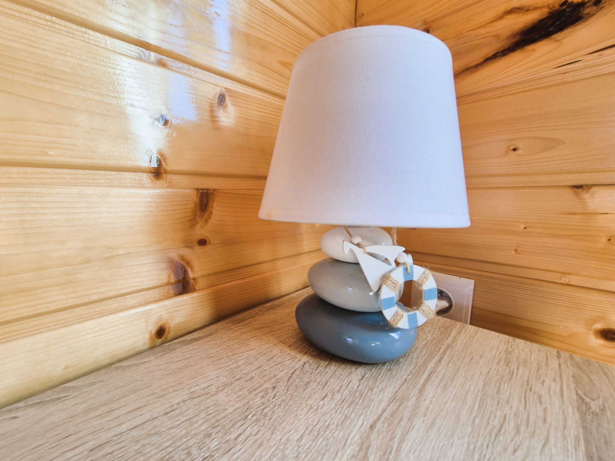 A wooden cabin interior with a lamp on a wooden table.