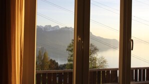 A view through a window with a wooden railing, overlooking a mountainous landscape with trees and power lines. - Gais Alpins by Interhome (Montreux)