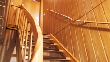 Un escalier en bois, doté d’une rampe et d’une porte en haut.