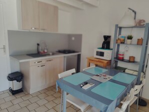 Een koelkast, een microgolfoven, kookgerei, borden en bestek