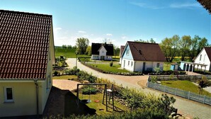 Een woonwijk met huizen, een speeltuin en een verharde weg.
