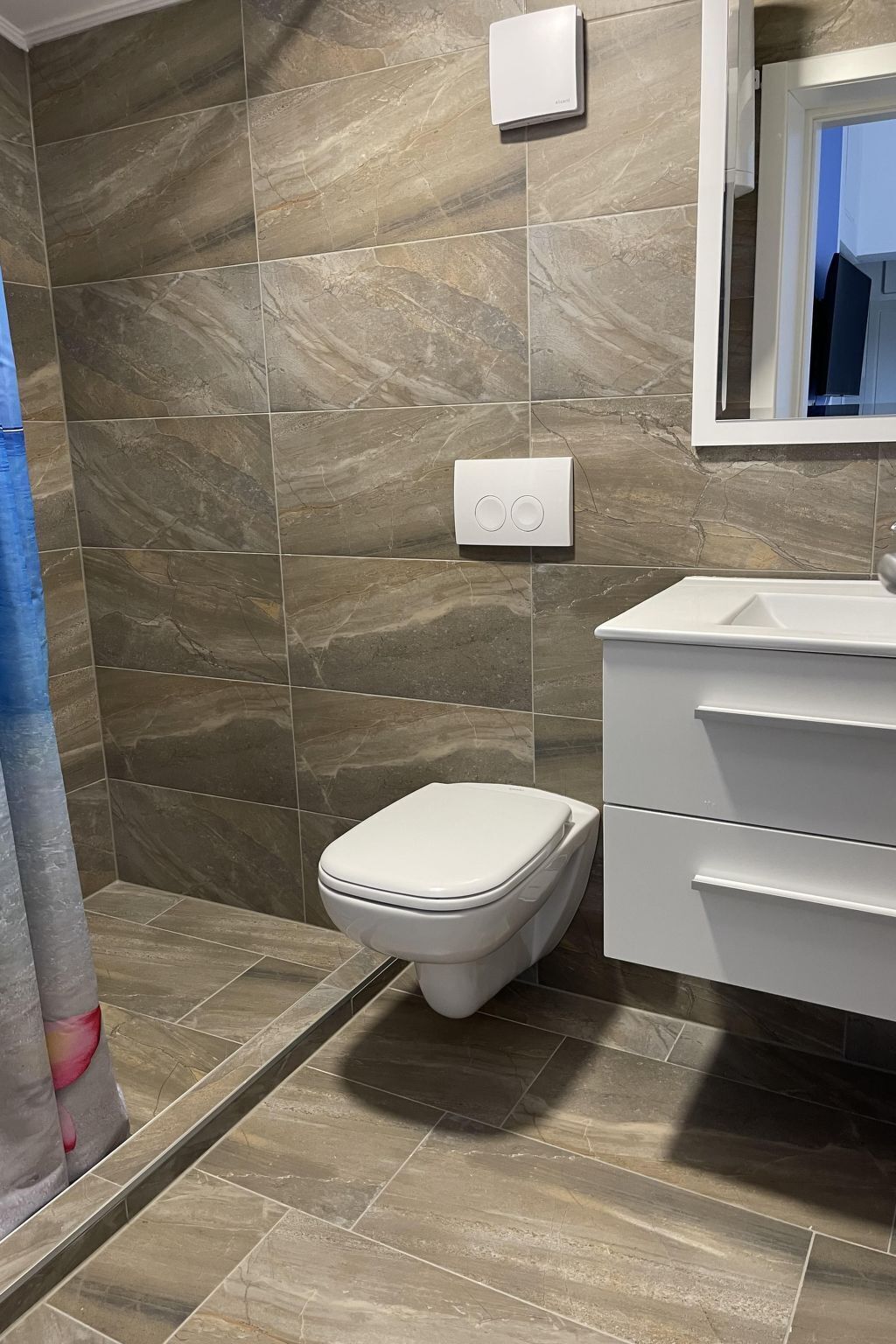 Un baño con inodoro, lavabo y cabina de ducha.