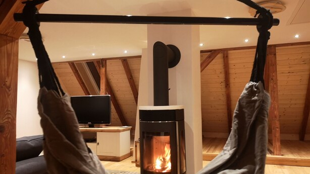 Una habitación acogedora con chimenea, televisor y una hamaca.