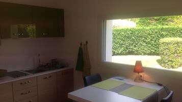 Een koelkast, een magnetron, een vaatwasser, kookgerei, borden en bestek