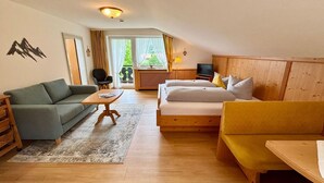 Une pièce confortable avec un canapé, un lit, une table et un téléviseur.