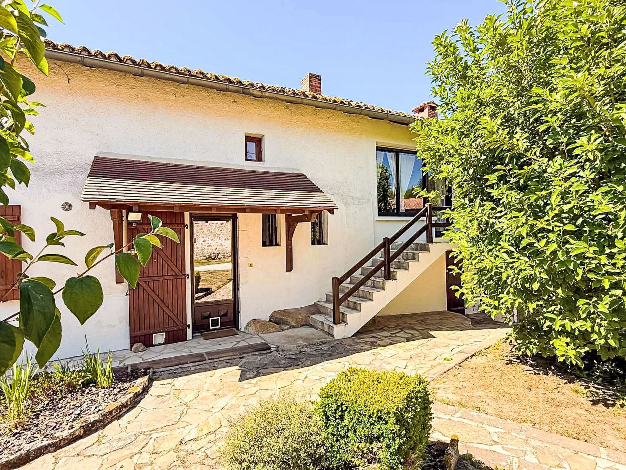 A house with a stone staircase, a wooden door, and a small porch.