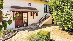 Ein Haus mit einer Steinstufe, einer Holztür und einer kleinen Veranda.