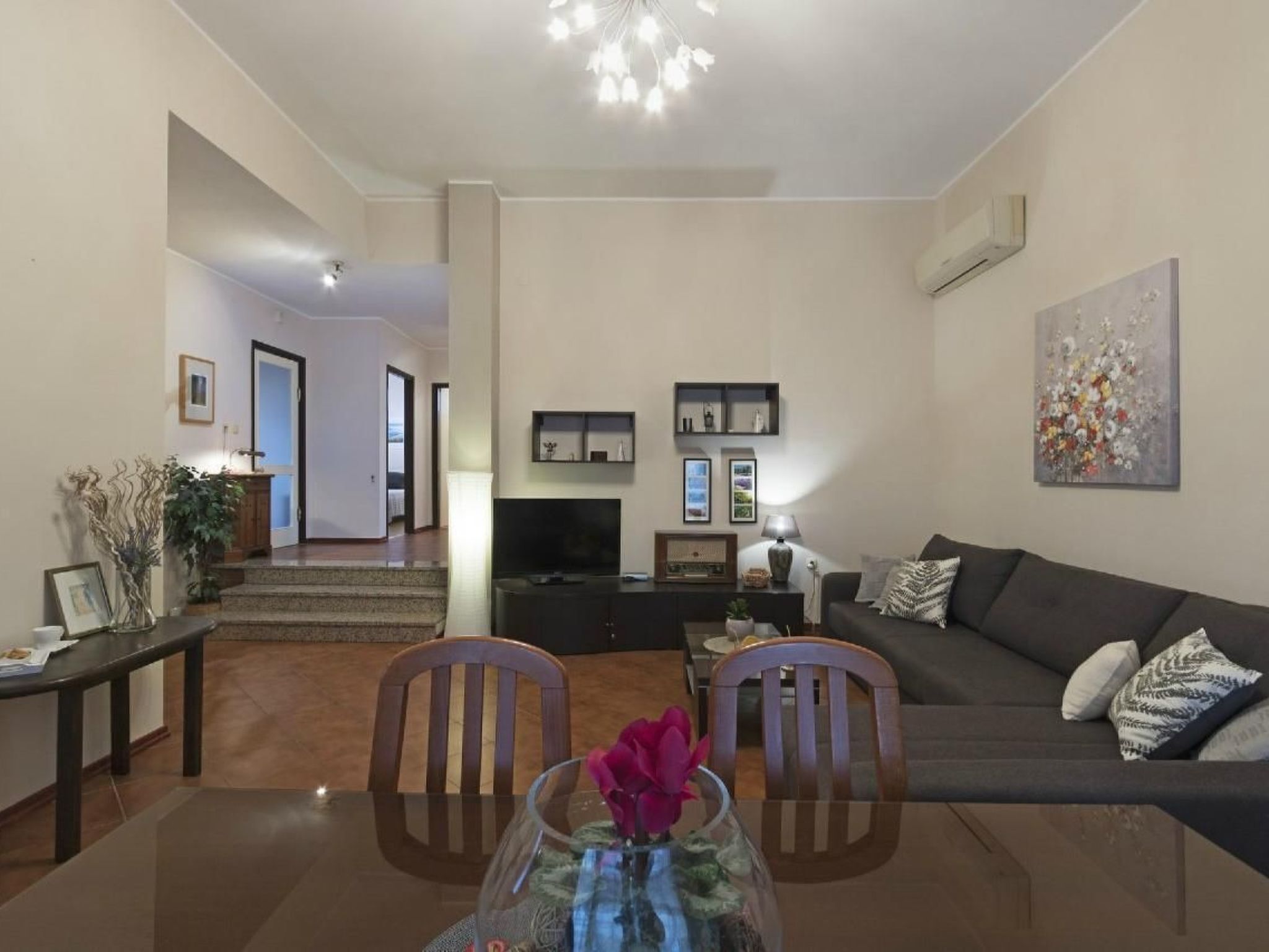 A modern living room with a TV, sofa, and dining area.