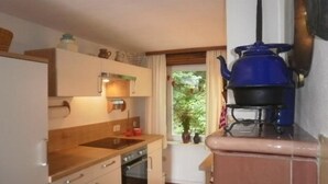 Una cucina compatta con lavello, forno e piano cottura blu.